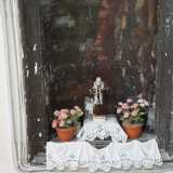 Al di sotto una statuetta in ceramica di San Pio circondata da vasetti con fiorellini rosa e bianchi � invece testimonianza di un culto tutto contemporaneo